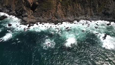 Filmische-Drohnenaufnahmen-Aus-Der-Luft-Fangen-Die-Herrlichen-Meereswellen-Ein,-Die-An-Die-Küste-Von-Big-Sur-Krachen