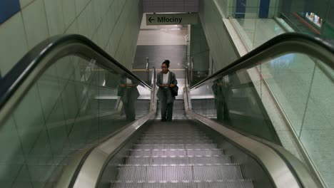 mujer en una escalera mecánica en una estación subterránea