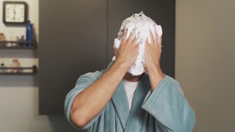 portrait of a crazy man smearing foam on his face and laughing