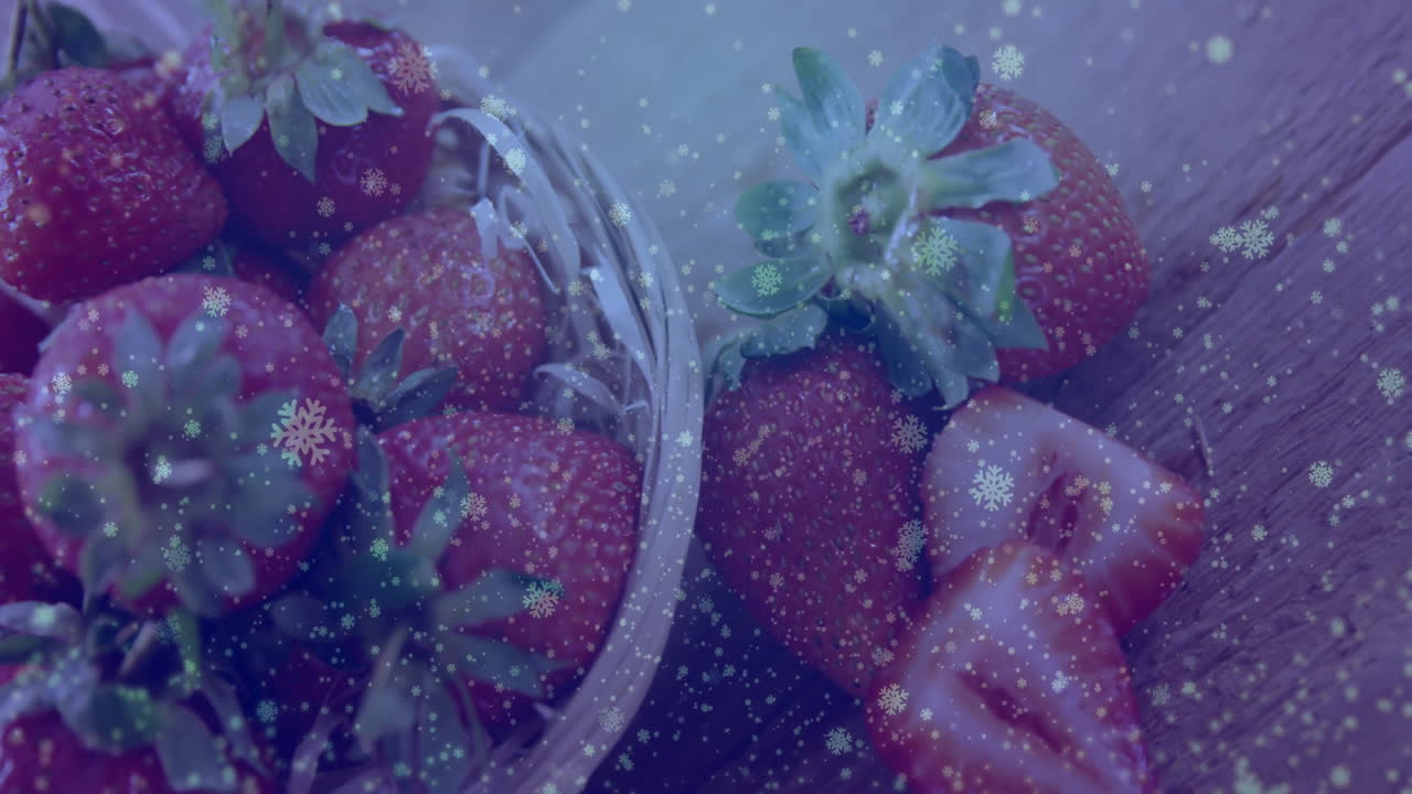 Basket of strawberries with snowflake animation overlaying scene in winter setting