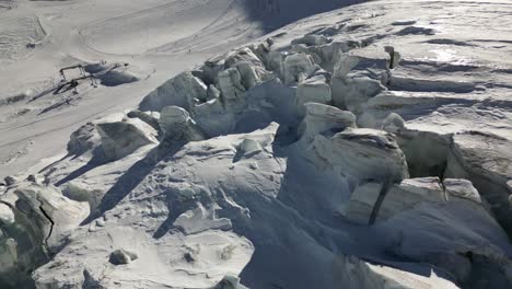 aerial-view,-glacier-in-the-swiss-alps,-icy-peaks-with-a-blue-color