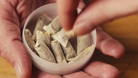 snus nicotine tobacco close up, pack of tobacco for gum. unhealthy addiction. man opening box with snus and taking one.