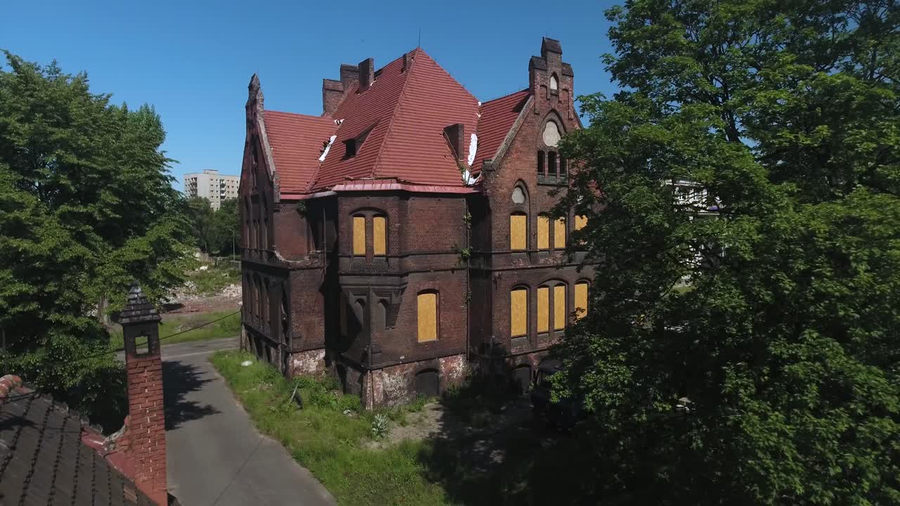 벽과 푸른 나무로 둘러싸인 오래된, 버려진 벽돌 빌딩, 벽으로 인 창문, 은 여름날, 동적 4k 드론 촬영