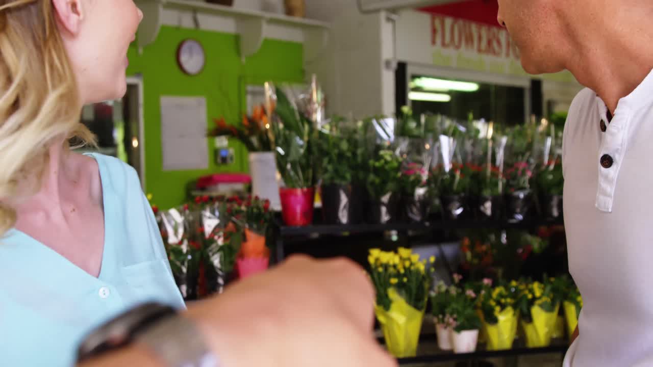 cliente señalando una flor en una floristería
