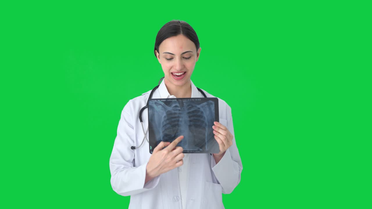 doctora india feliz explicando rayos x a la pantalla verde del paciente
