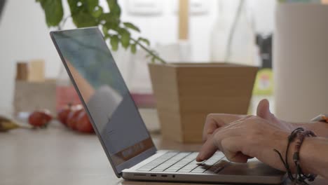 Person-is-typing-at-his-laptop-keyboard,-recorded-at-indoor-household-environment,-digital-distant-work-concept