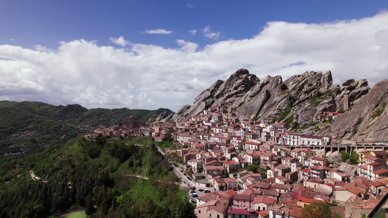 Aerial orbit view of Pietrapertosa alpine town near rocky mountain, Italy
