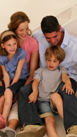 happy family sitting on floor in their new home