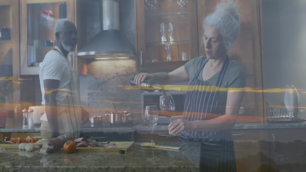 Elderly couple in kitchen with wine pouring over sunset landscape animation