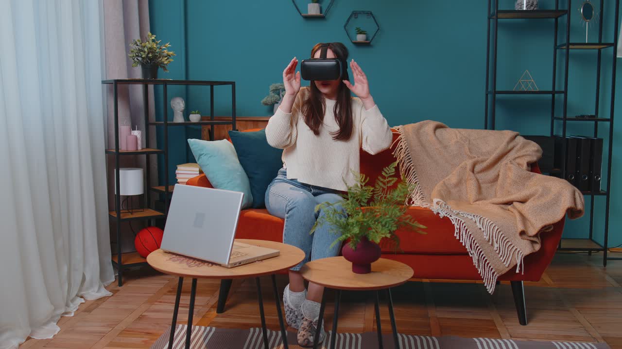 젊은 소녀는 집에서 가상 현실 헤드 ⁇  안경을 사용하고 손으로 제스처를 하는 3d 비디오 게임을 합니다.