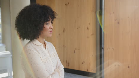 smiling businesswoman with curly hair standing confidently in modern office