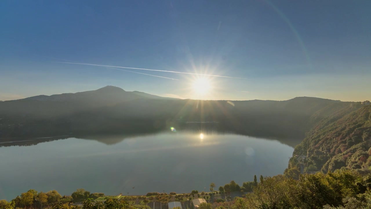 Alba sul Lago Albano: Timelapse panoramico della costa all'alba, Provincia di Roma, Lazio, Italia Centrale. La luce del mattino dipinge il paesaggio con la bellezza verdeggiante degli alberi.