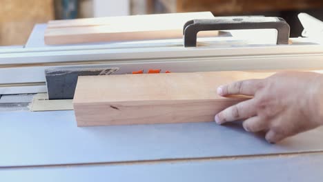 woodworker cutting wooden planks on the table saw