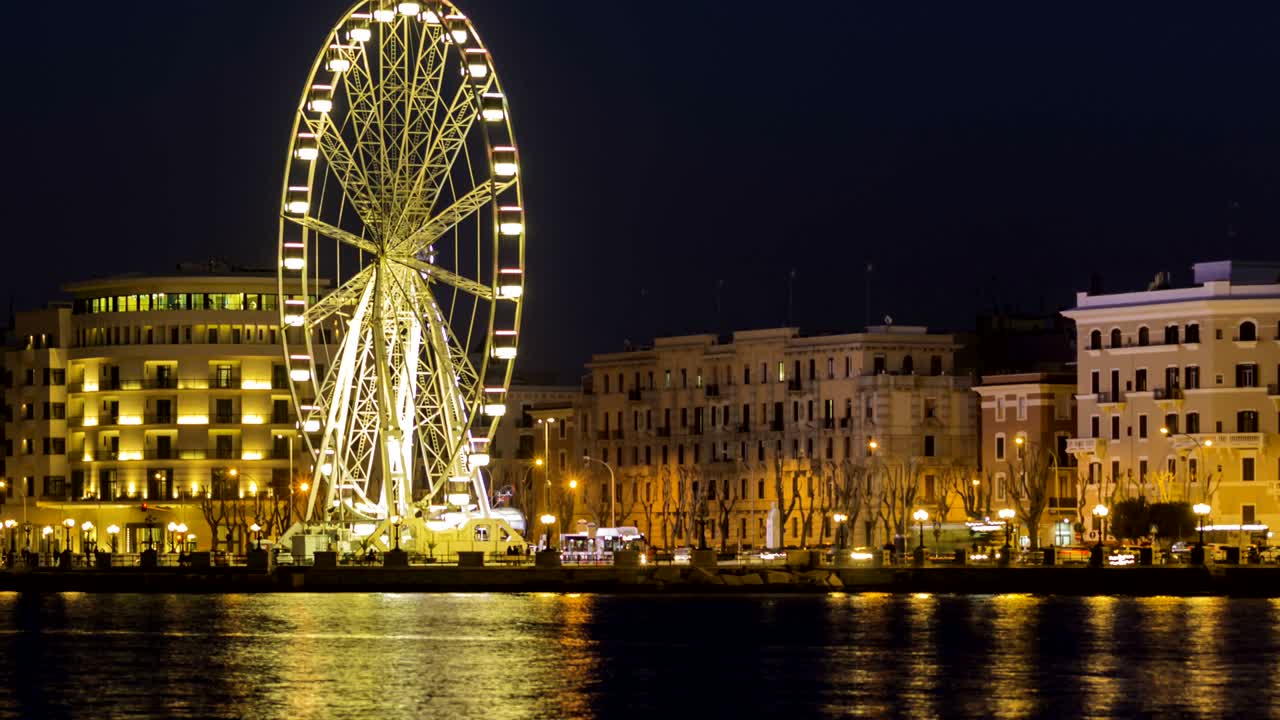 바리의 해안가에 있는 조명된 거대한 페리스 의 파노라마 야간 풍경