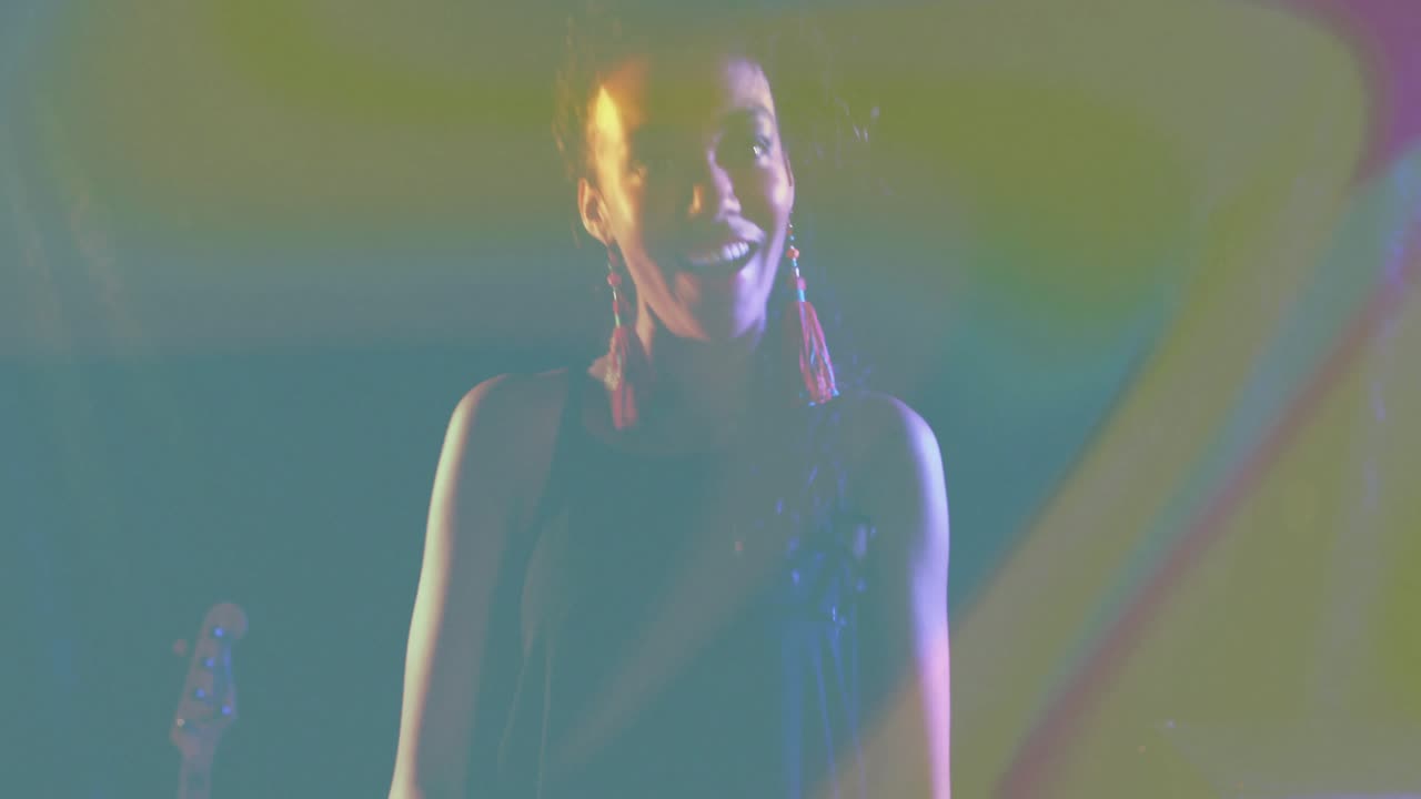 La pressione di un tasto avvia la ripresa della telecamera, rivelando un musicista sotto luci arcobaleno che energizza il pubblico.
