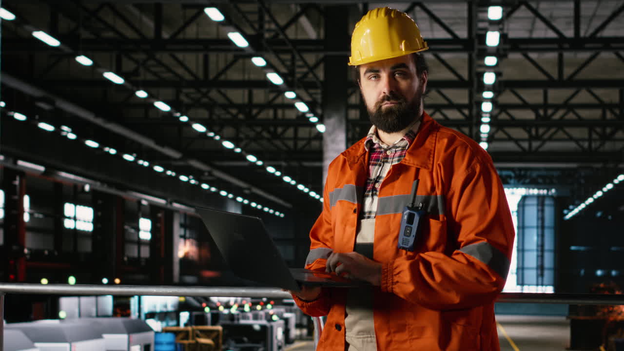 Ingegnere con cappello che ispeziona una struttura metallica in uno stabilimento industriale