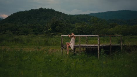 woman sitting on a wooden platform in a forest