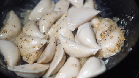 pierogis añadido a la sartén con pinzas rojas en cámara super lenta