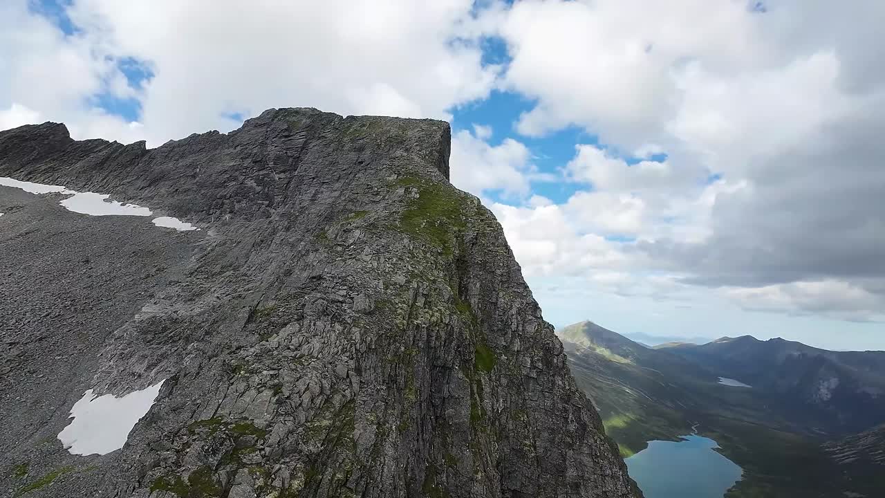 An FPV drone conquers nature's heights, ascending a majestic peak, revealing breathtaking vistas from a soaring perspective