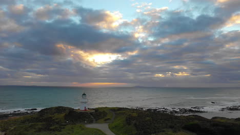 Vista-Aérea-De-Un-Faro-Al-Atardecer-A-Lo-Largo-De-La-Pintoresca-Costa-De-Nueva-Zelanda