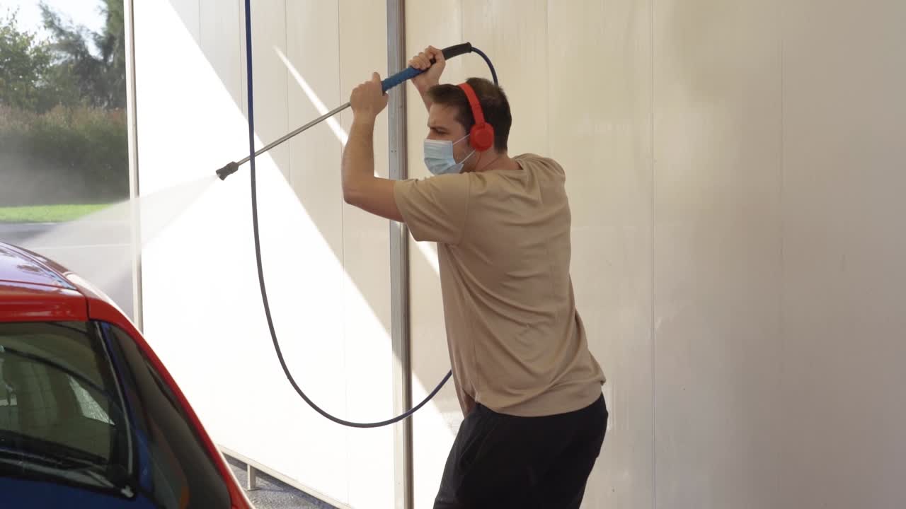 Dancing man cleaning the car animated while listening to music and wearing a mask