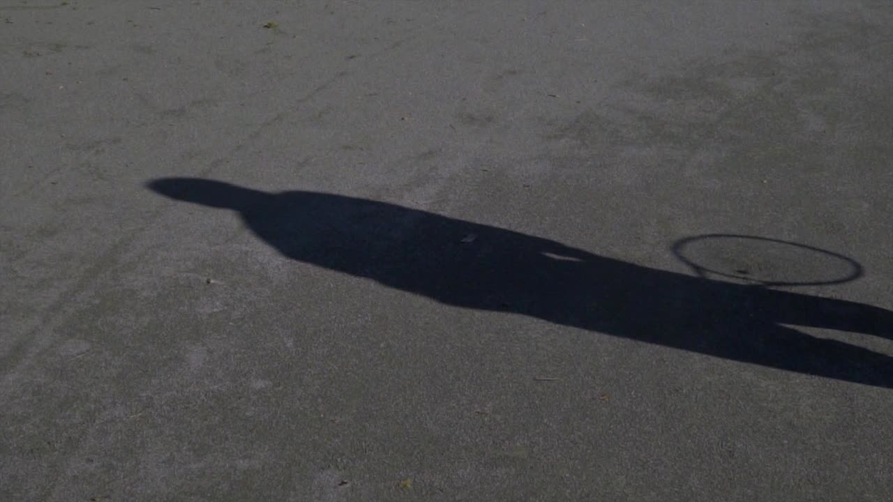 테니스에서 서브를 할 때 테니스 선수의 그림자