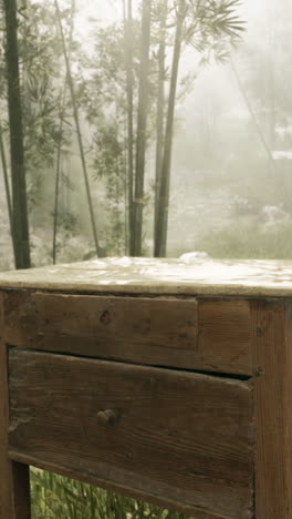 mesa de madera vintage en un bosque de bambú con niebla