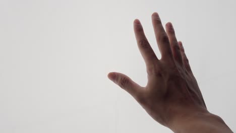 mano tocando la luz blanca que irradia en la superficie