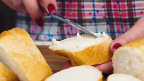 manos femeninas untan mantequilla en el pan