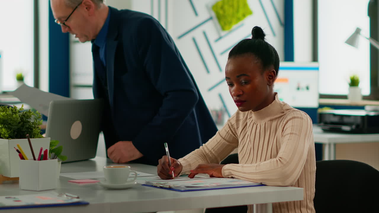 African businesswoman analysing report and looking at camera smiling