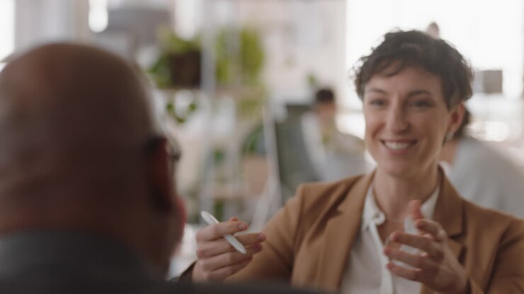 young business woman chatting to intern discussing job interview colleagues having conversation in office enjoying teamwork