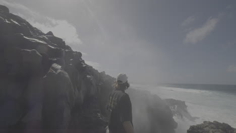 ocean waves crashing over volcanic rocks