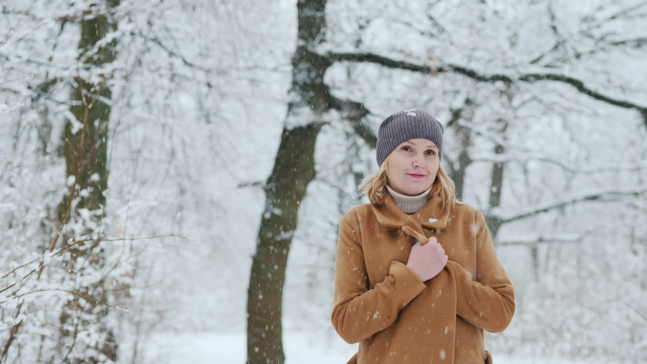 세련된 중년 여성이 스노우 파크를 산책합니다.