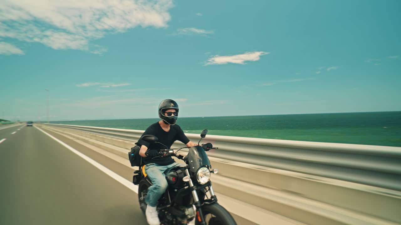 Man riding a motorcycle on a coastal road