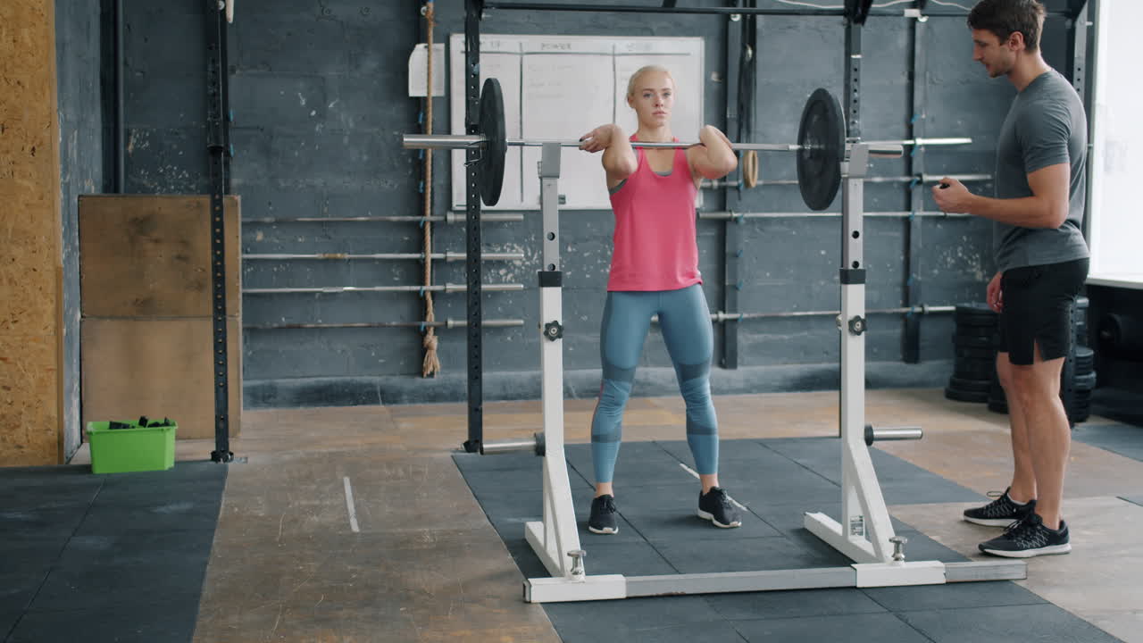 Donna che solleva pesi con un personal trainer