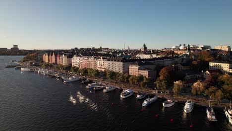 classic colorful waterfront buildings and ships in stockholm, sweden, aerial 4k