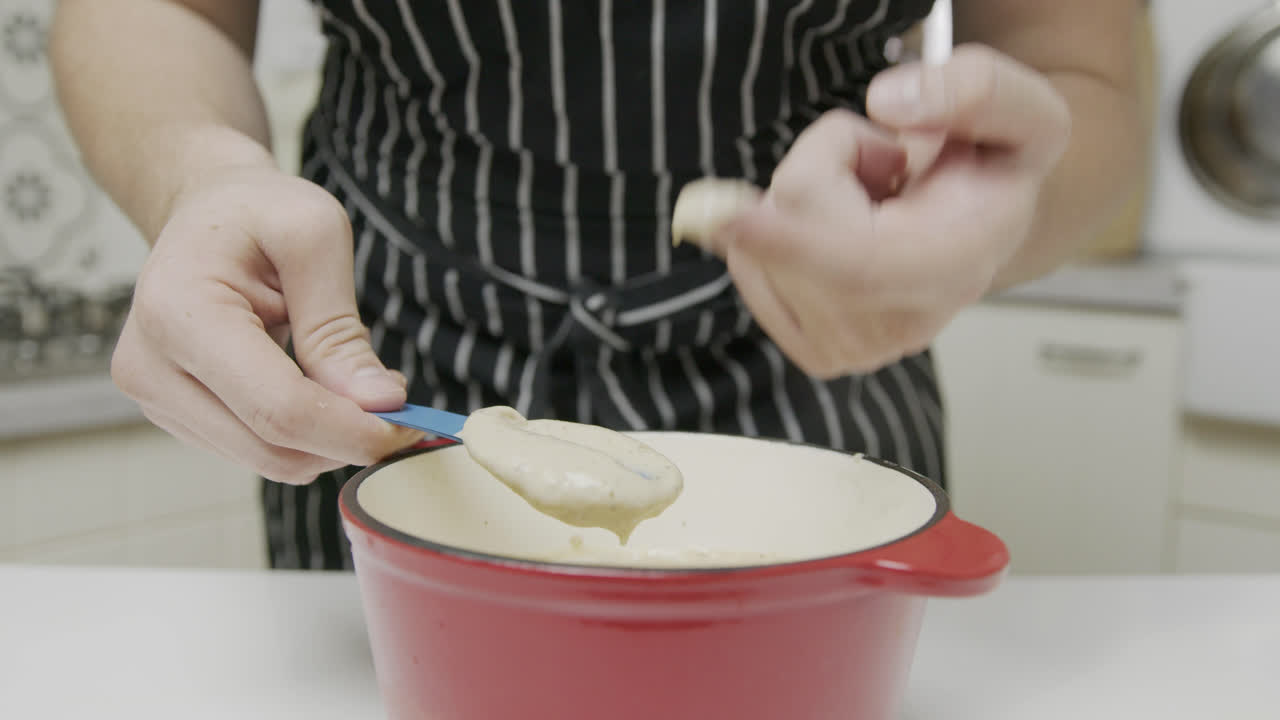 요리사가 소스 믹스의 일관성을 확인합니다.