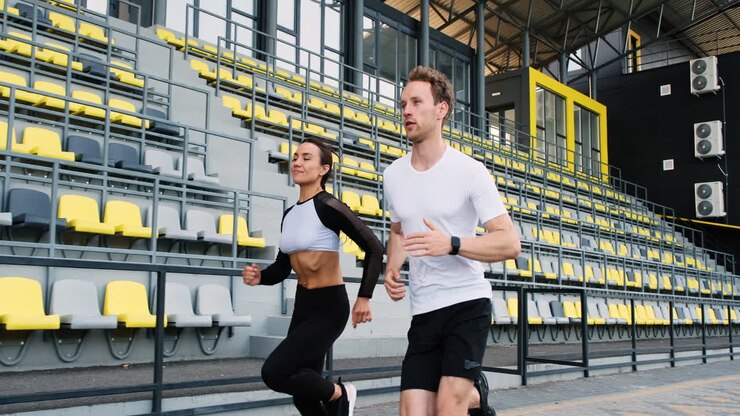 Sportive Couple Running Fast In The Stadium
