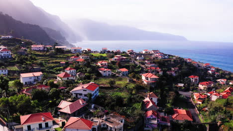 Vista-Aérea-Que-Muestra-Un-Pueblo-Costero-Rural-Con-Hermosas-Vistas-Al-Océano-Durante-La-Luz-Del-Sol