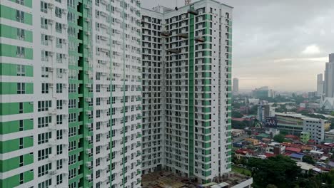 Aerial-of-Cebu-City-high-rise-buildings,-panning-to-cityscape-in-distance