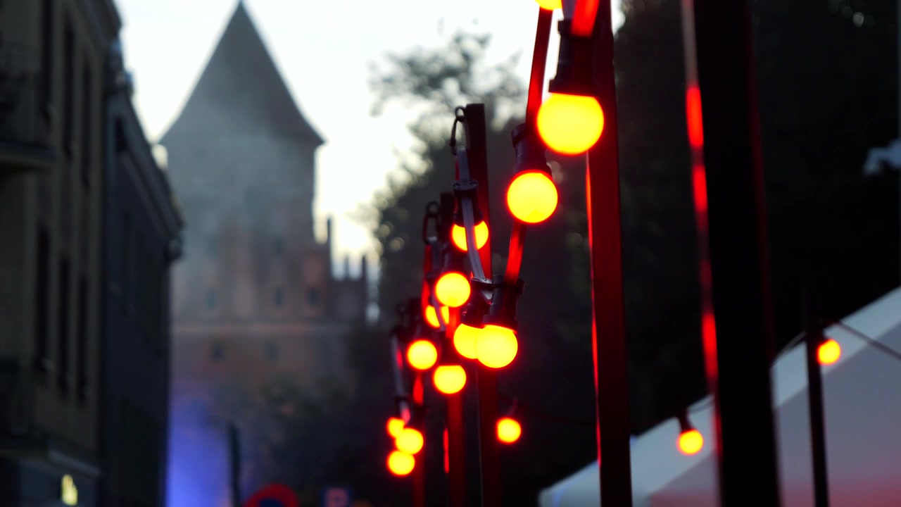 Decorative bulbs glowing softly outdoors in the evening with a warm cinematic atmosphere