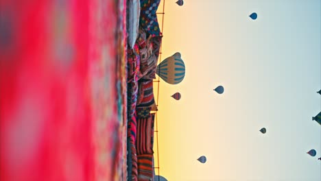 Turkish-rugs-overlooking-the-captivating-Cappadocia-horizon-and-fiery-hot-air-balloons-at-the-background