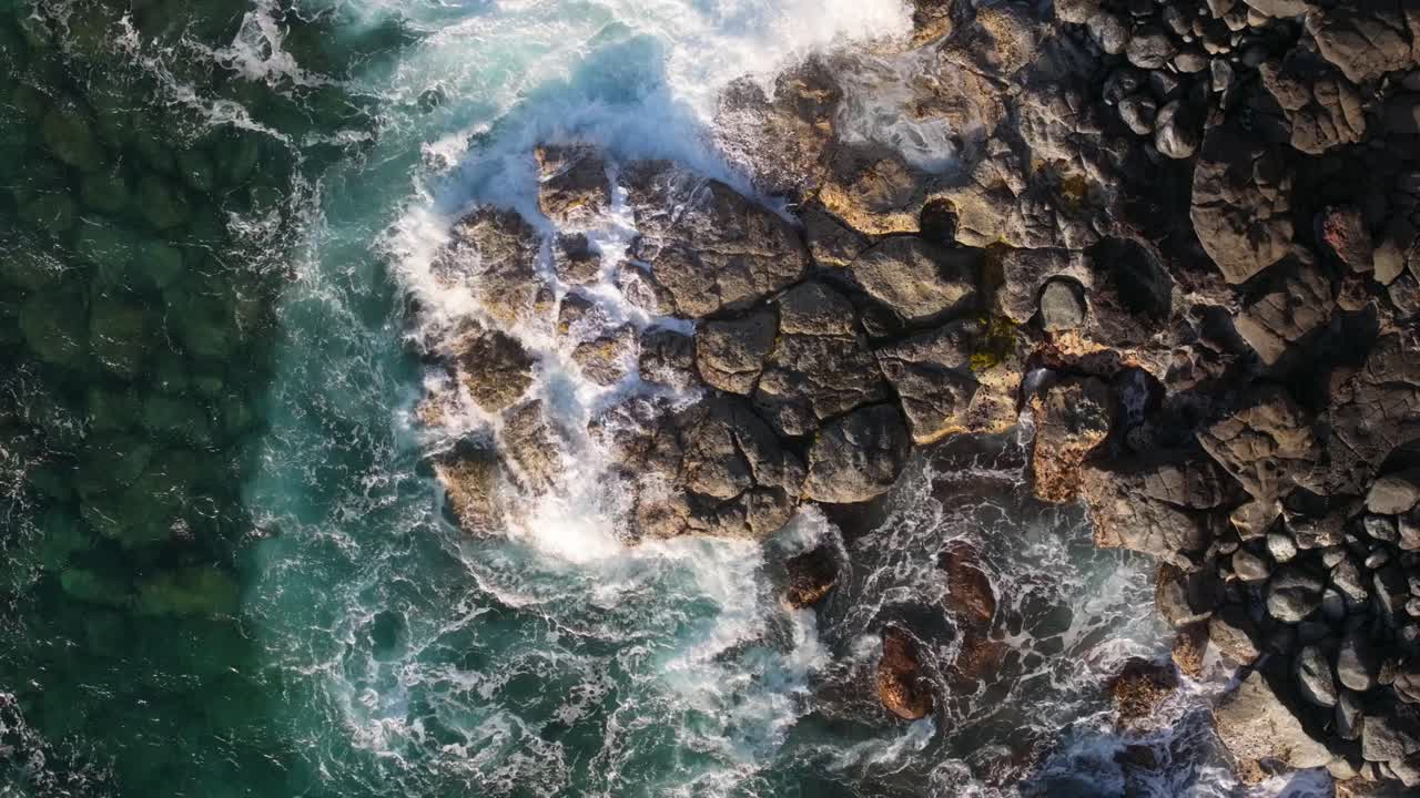 Vista Aerea di Onde Potenti che si Infrangono su una Costa Rocciosa