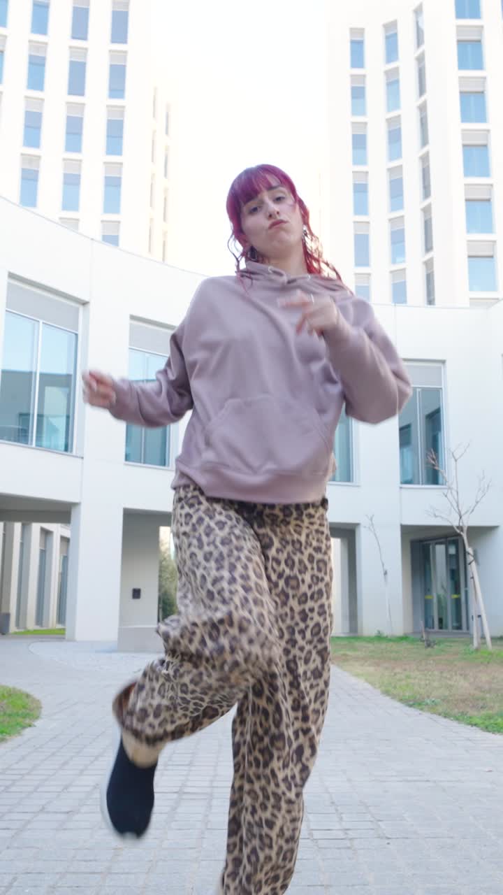 Young urban dancer performing outside modern building