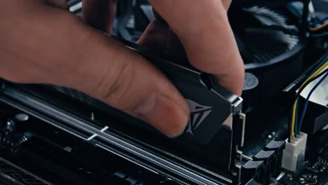 inserting a stick of memory into a motherboard