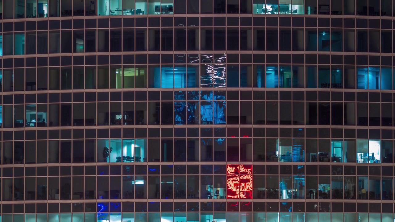 Vista ravvicinata delle finestre degli uffici nel Centro Affari Internazionale della Città di notte, timelapse dall'alto.