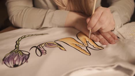 person painting a design on a t-shirt