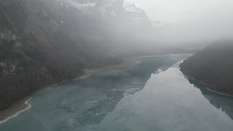 Klöntalersee-Glarus-Switzerland-slow-rising-shot-goes-through-the-mist-to-see-the-lake-and-beauty-below