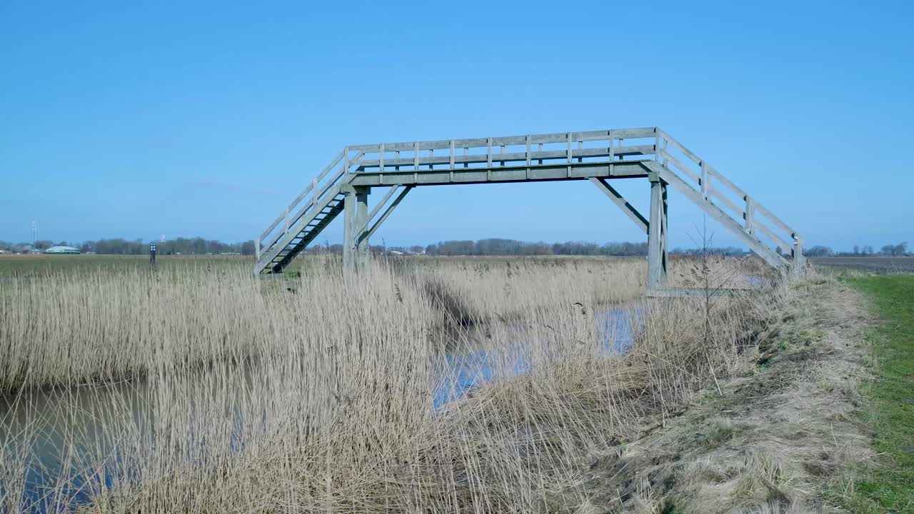 Wooden Footbridge Over a Canal in a Rural Landscape