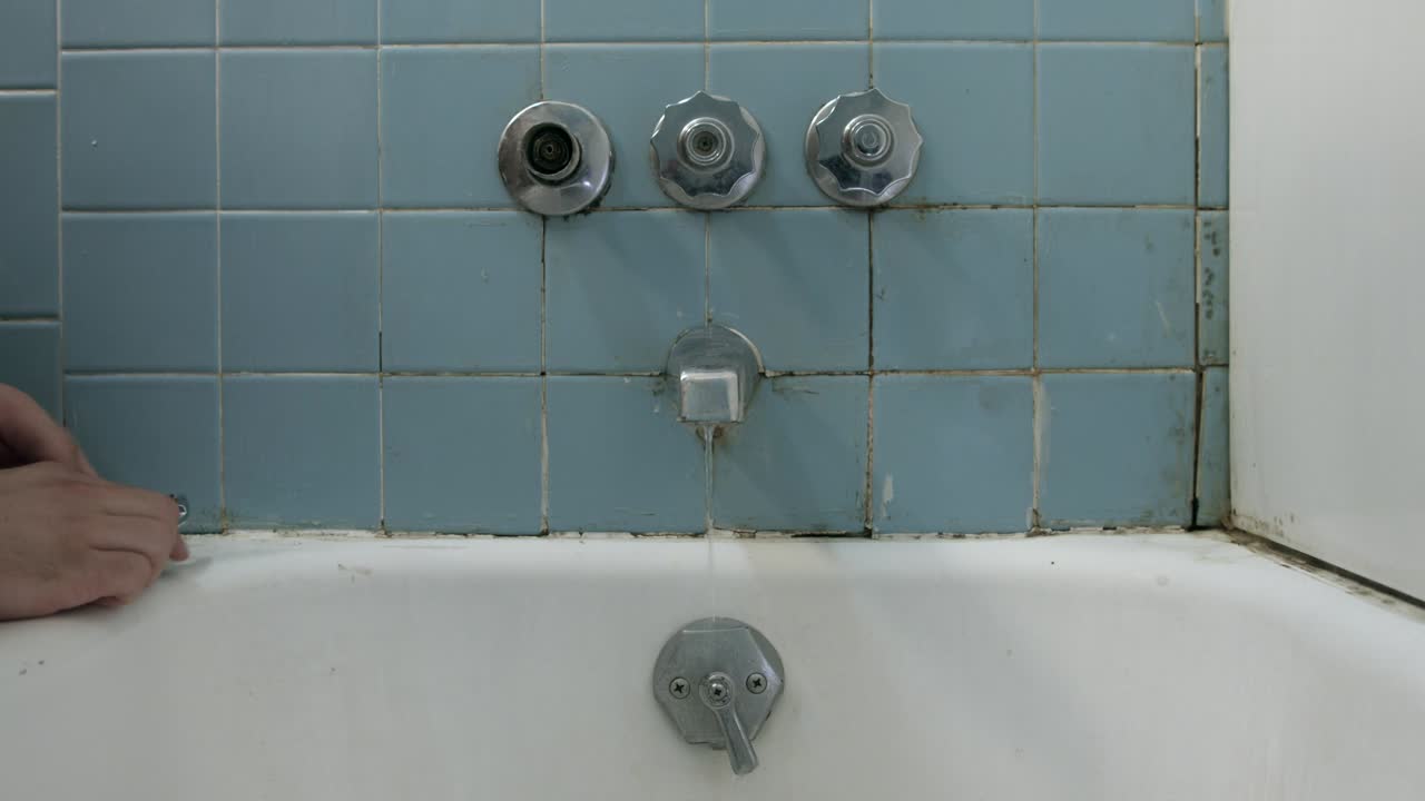 用扳匙修理漏水的水龙头 - 中间镜头
